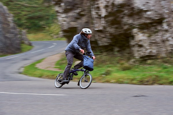 Homme descendant une colline à vélo Brompton