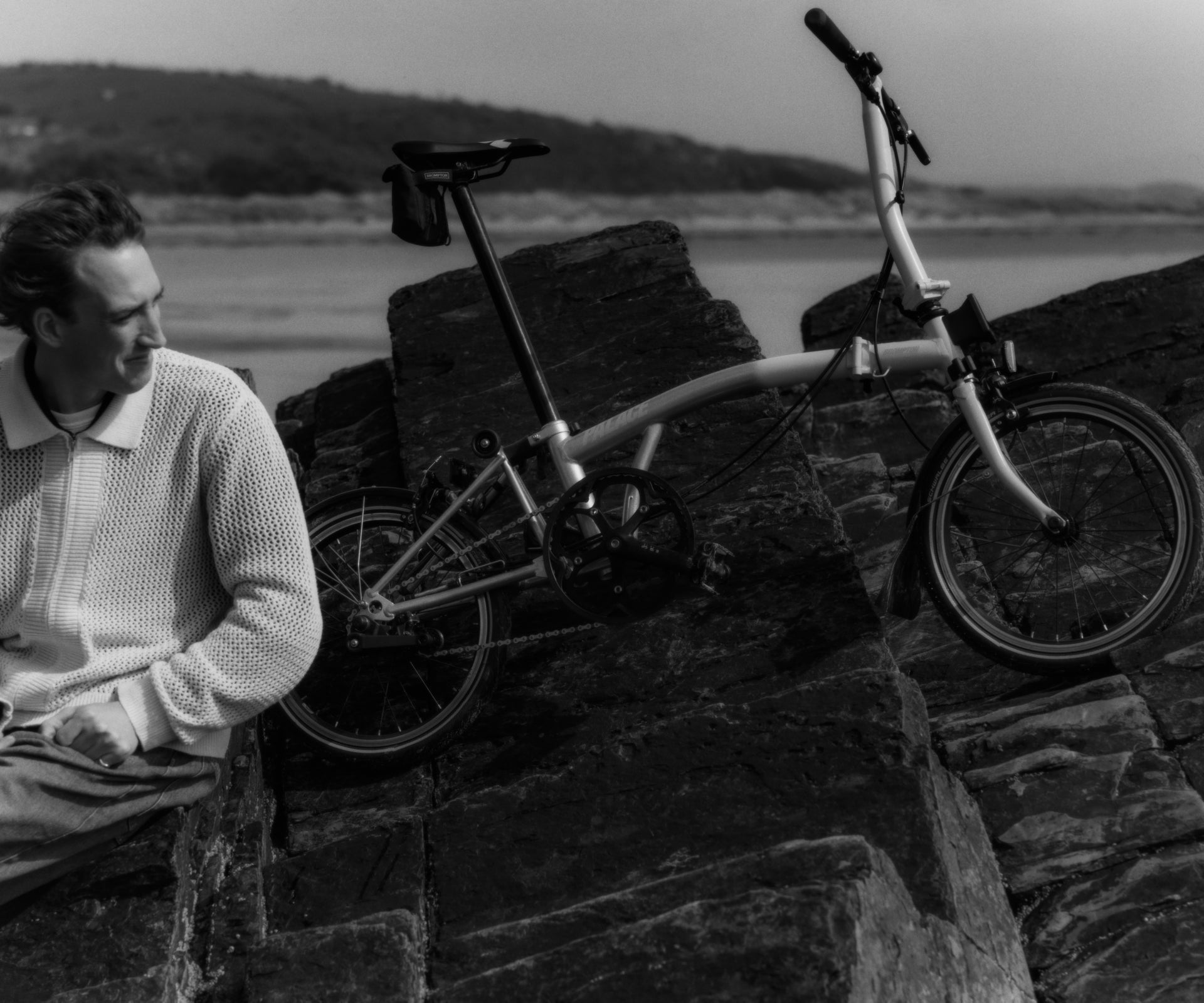 Vélo pliant Brompton Palace sur des rochers déchiquetés près de la plage
