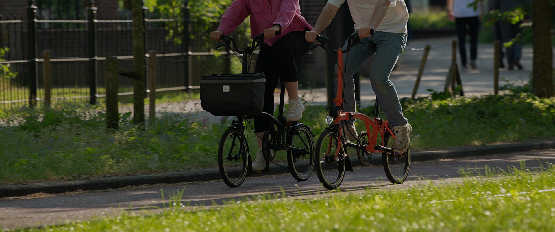 Deux personnes heureuses conduisant des vélos pliants Brompton dans une belle rue