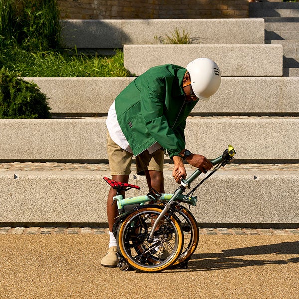 Un homme plie un vélo Brompton x Tour de France