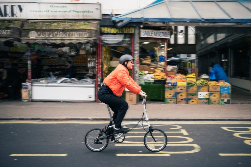 person riding a brompton A Line bike down a road in London