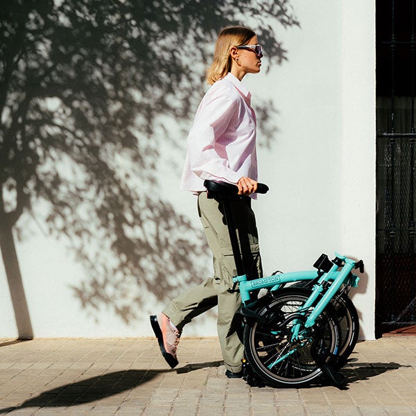 Personne poussant un vélo Brompton plié