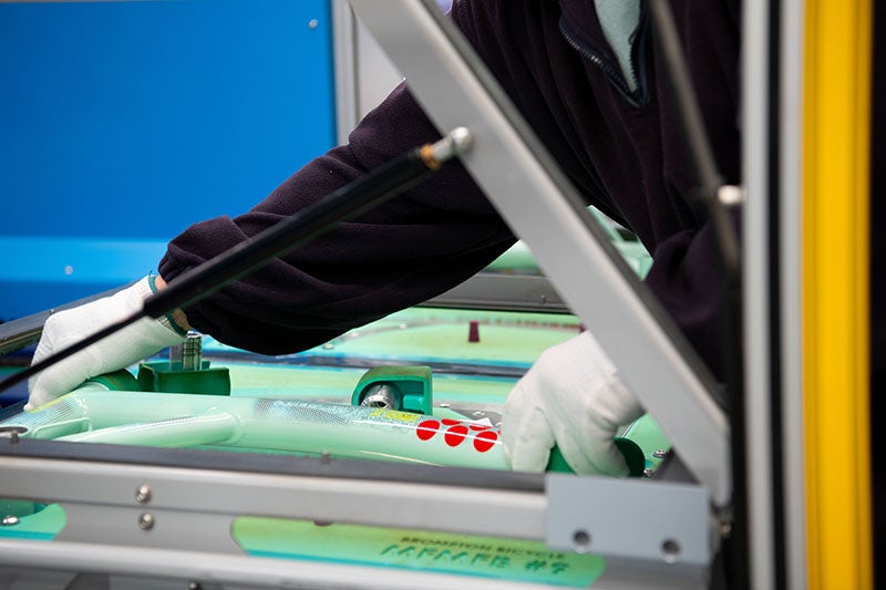 Personne manipulant un cadre de vélo Brompton dans une usine