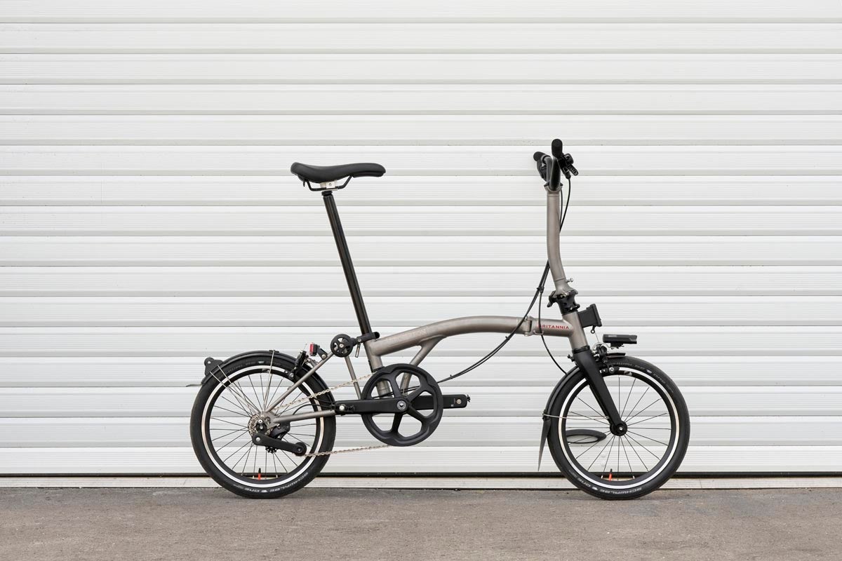 a brompton t line folding bike in front of white background