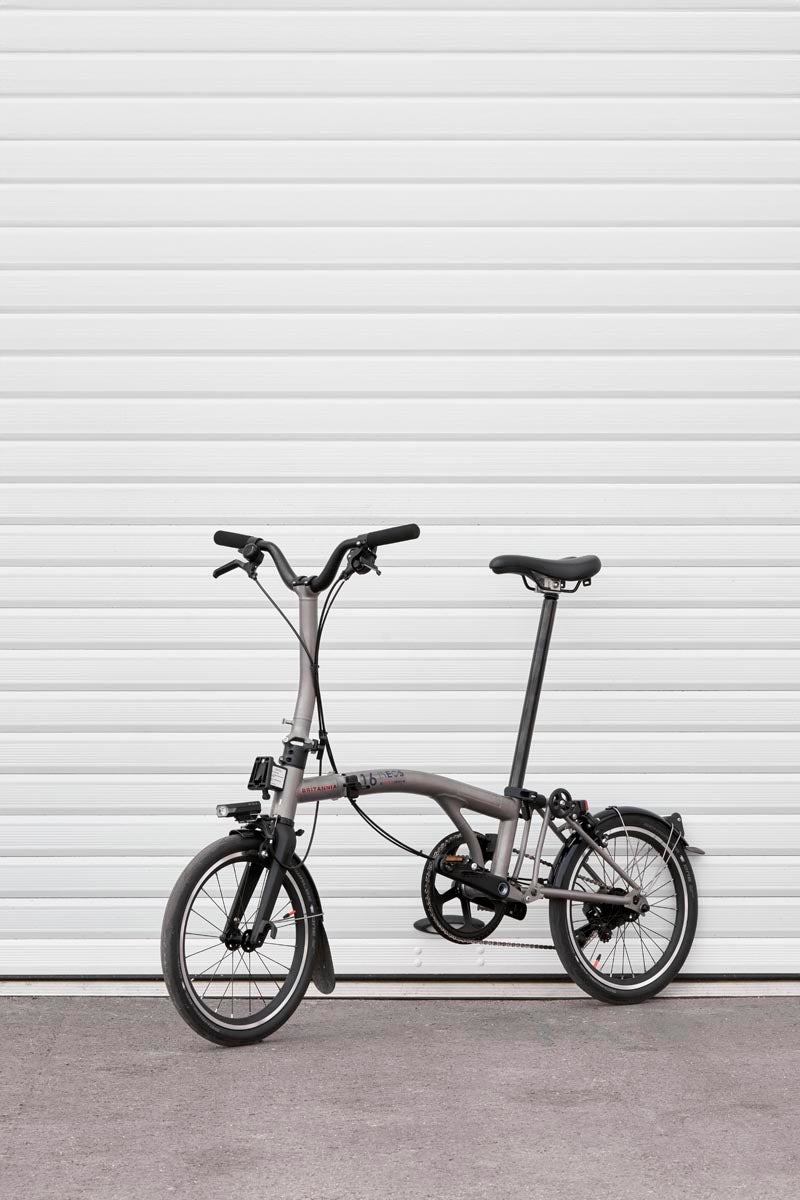 a brompton t line folding bike in front of white background