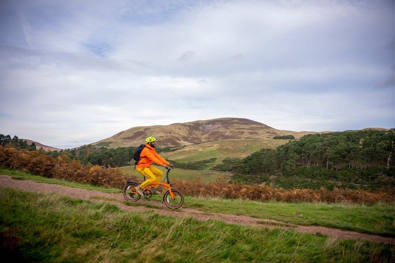 Personne roulant sur un vélo Brompton G Line sur un chemin de gravier
