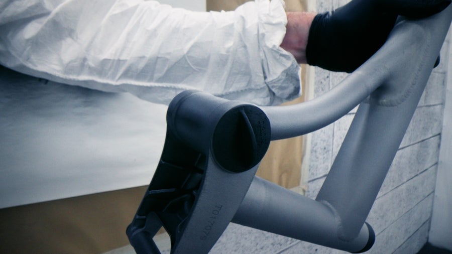 Person sanding a Brompton bike frame