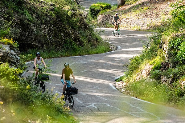 Des gens descendent une colline à vélo Brompton