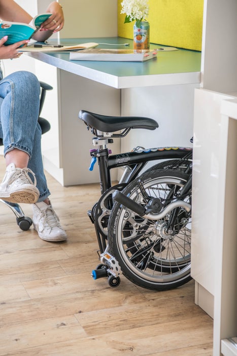 Personne assise avec un vélo Brompton plié