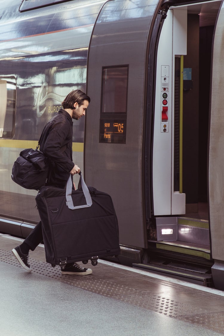 person carrying a brompton bike in carrier onto train in paris
