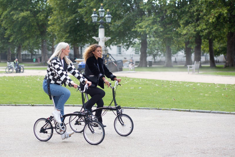 Deux personnes roulant sur des vélos Brompton