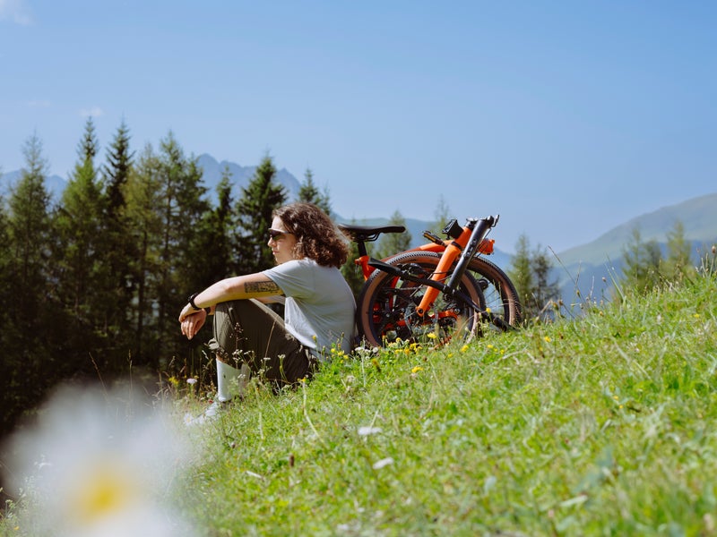 Personne assise devant un vélo plié Brompton