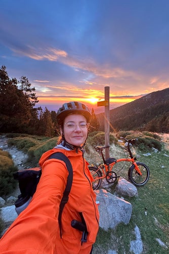 Sophie au sommet d'une montagne avec un vélo Brompton