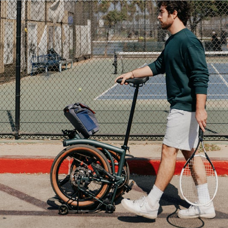 Un mec pousse un Brompton Electric G Line en mode SuperRoll+.